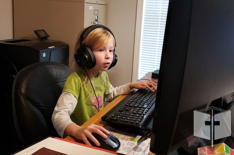 Young girl playing on a computer.